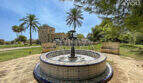 Gartenanlage der Finca mit kunstvollem Mosaikbrunnen, Palmen und historischem Gutshaus in Colònia de Sant Jordi.