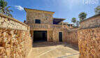 Einfahrt zur exklusiven Finca in Colònia de Sant Jordi mit Natursteinmauern, Garage und Balkon.