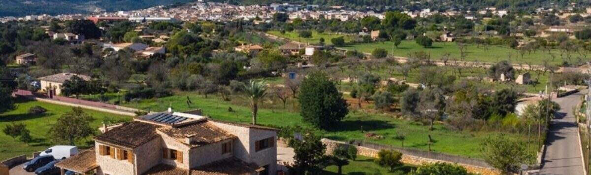 Luftaufnahme einer mallorquinischen Steinfinca in Lloseta mit Pool, Sonnenterrasse und Tramuntana-Bergblick.