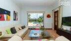 Helles Wohnzimmer mit Ledersofa, Glastisch & Poolblick durch große Schiebetür, Villa Lloseta