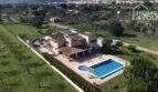 Luftaufnahme einer mallorquinischen Villa in Lloseta mit großem Salzwasserpool, Terrasse und grünem Garten.