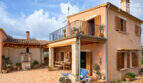Finca Ses Salines: Mediterraner Innenhof mit Terrasse, Holzläden, Balkon und stimmungsvoller Beleuchtung.