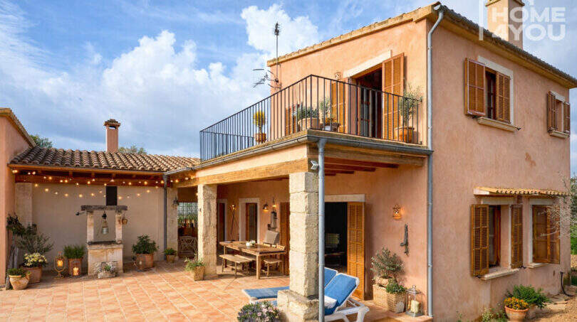 Finca Ses Salines: Mediterraner Innenhof mit Terrasse, Holzläden, Balkon und stimmungsvoller Beleuchtung.
