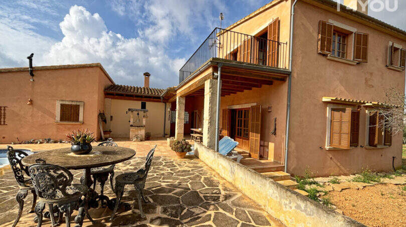 Rustikale Finca in Ses Salines: Steintetrasse mit Schmiedeeisenmöbeln, Pool, Außenküche und Balkon.