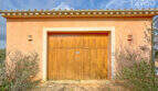 Garage der Finca in Ses Salines mit Holztor, mediterranem Putz und Terrakotta-Dach