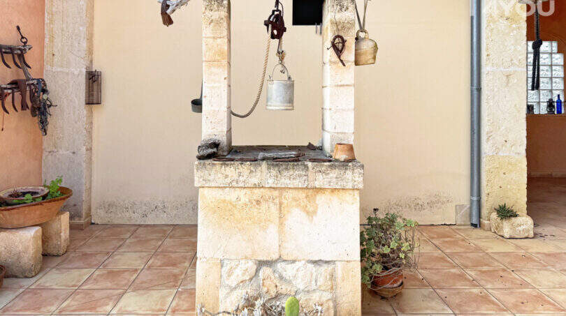 Rustikaler Steinbrunnen mit Seilzug auf der Terrasse der Finca in Ses Salines