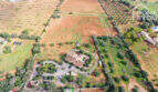Luftaufnahme Finca Ses Salines mit Pool, Terrassen, Garage, Nebengebäuden und landwirtschaftlichen Feldern.