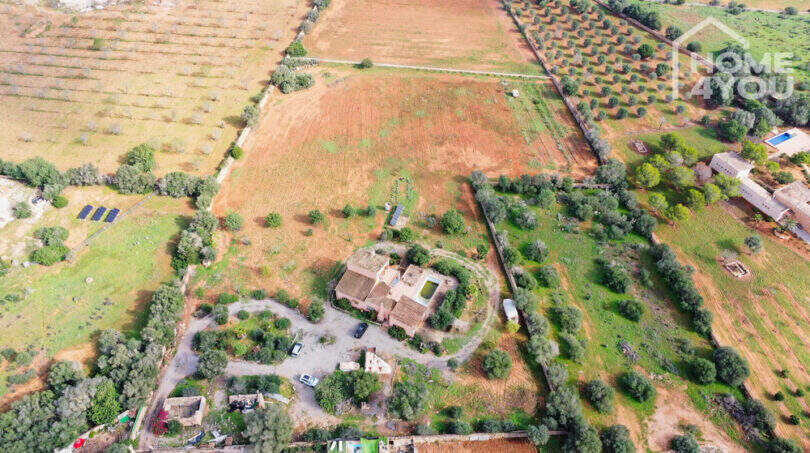 Luftaufnahme Finca Ses Salines mit Pool, Terrassen, Garage, Nebengebäuden und landwirtschaftlichen Feldern.