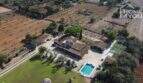 Luftaufnahme mediterraner Finca Santa Margalida: Haupthaus, Nebengebäude, Pool & Padelplatz auf 8.970 m²