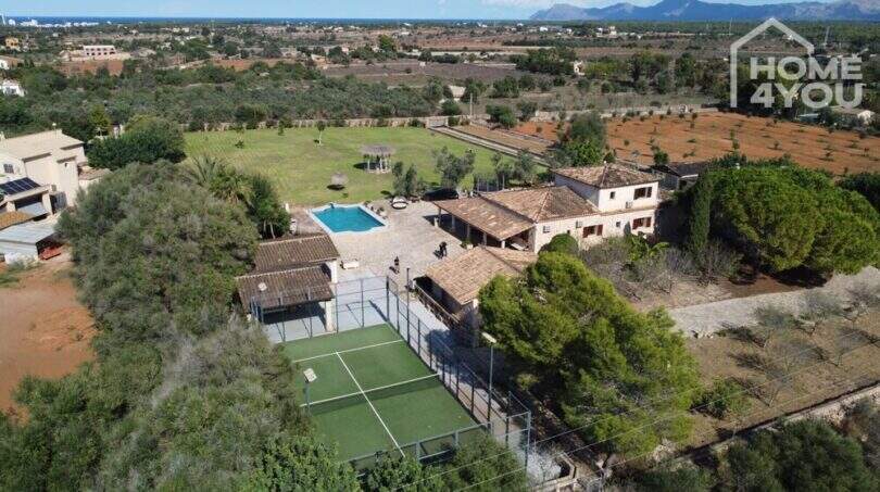 Luftaufnahme mediterrane Finca Santa Margalida: Padelplatz, Pool, weitläufiges Grundstück, Bergblick