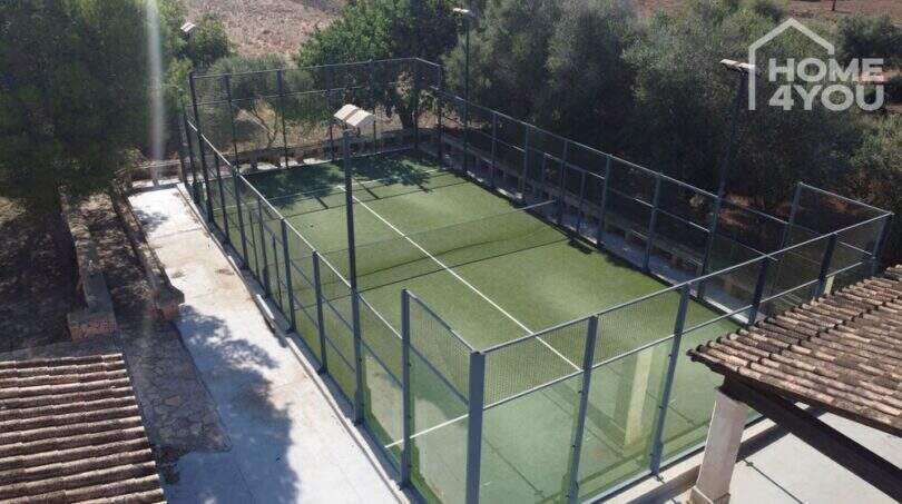 Privater Padelplatz mit Kunstrasen und Metallzaun, eingebettet in mediterrane Landschaft der Finca in Santa Margalida