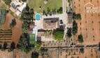 Luftaufnahme mediterraner Finca Santa Margalida: Haupthaus, Pool, Padelplatz, Garten & Felder, 8.970 m²