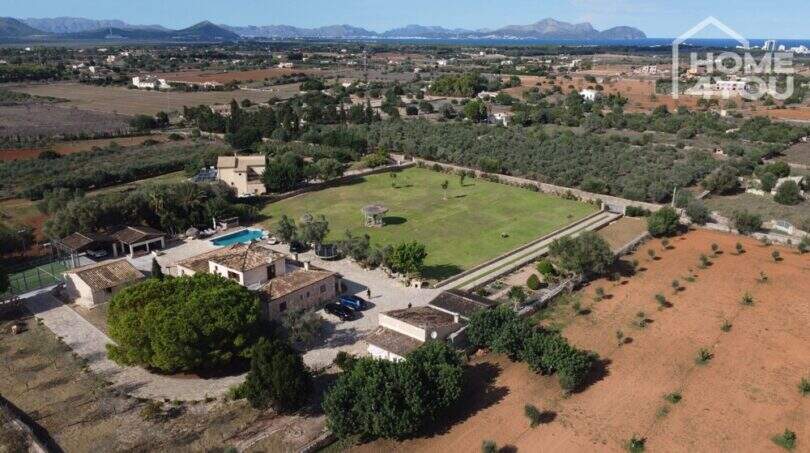 Luftaufnahme mediterrane Finca Santa Margalida: weitläufiges Grundstück mit Pool, Padelplatz & Meerblick