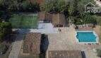 Luftaufnahme mediterrane Finca Santa Margalida: Pool, Padelplatz, Steinpatio und traditionelle Ziegeldächer