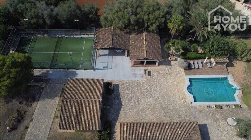 Luftaufnahme mediterrane Finca Santa Margalida: Pool, Padelplatz, Steinpatio und traditionelle Ziegeldächer