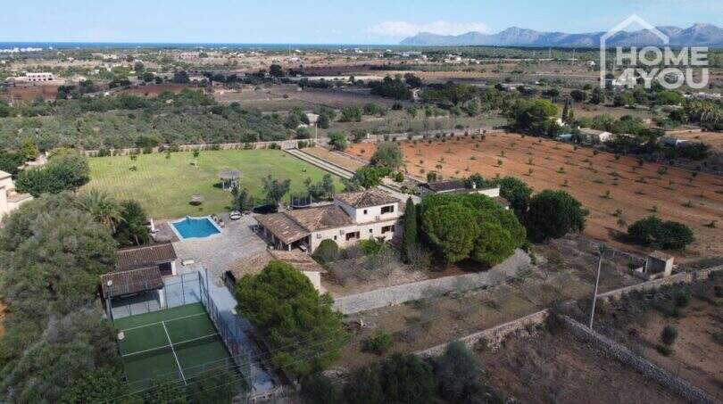 Luftaufnahme mediterrane Finca Santa Margalida: Haupthaus, Pool, Padelplatz, Grünflächen, Meerblick