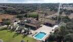 Luftaufnahme mediterrane Finca Santa Margalida: Pool, Padelplatz, weitläufiges Grundstück, Olivenbäume, Landhausarchitektur