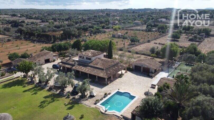 Luftaufnahme mediterrane Finca Santa Margalida: Pool, Padelplatz, weitläufiges Grundstück, Olivenbäume, Landhausarchitektur