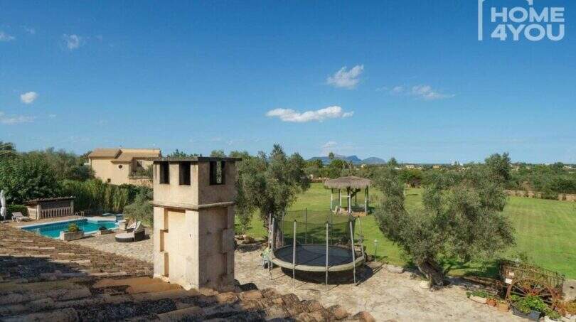 Blick vom Dach der Finca: Pool, Trampolin, Gartenanlage mit Olivenbäumen und Pergola, Mallorca-Panorama