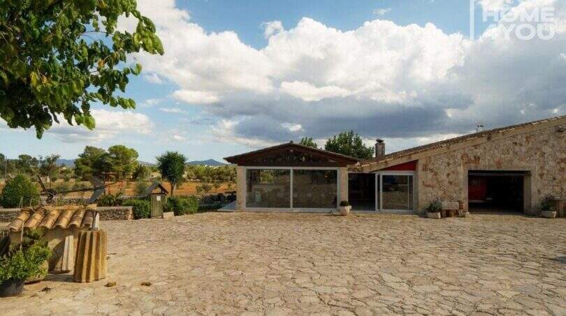 Steinerne Außenanlage einer mediterranen Finca in Santa Margalida mit Wintergarten und Panoramablick.