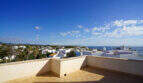 Dachterrasse des Penthouses in Cala d'Or mit Meerblick, weißen Häusern und blauem Himmel