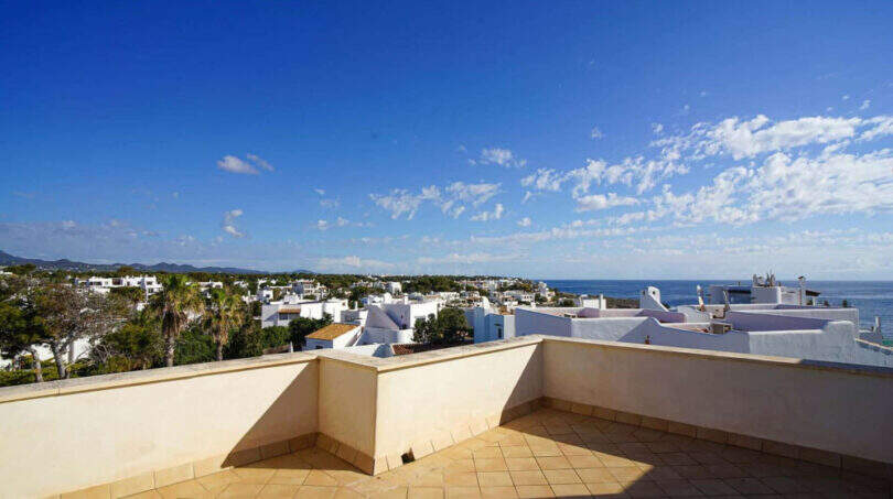 Dachterrasse des Penthouses in Cala d'Or mit Meerblick, weißen Häusern und blauem Himmel