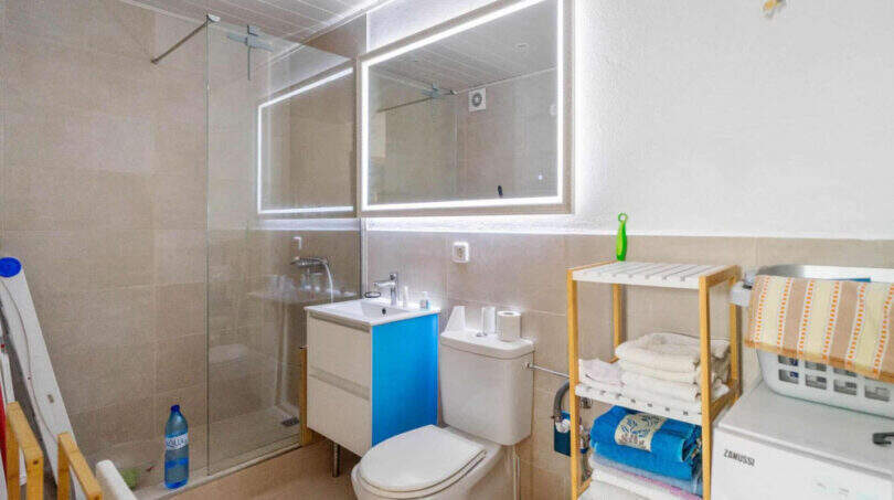 Modernes Badezimmer des Penthouses in Cala d'Or mit Dusche, beleuchtetem Spiegel und Waschmaschine