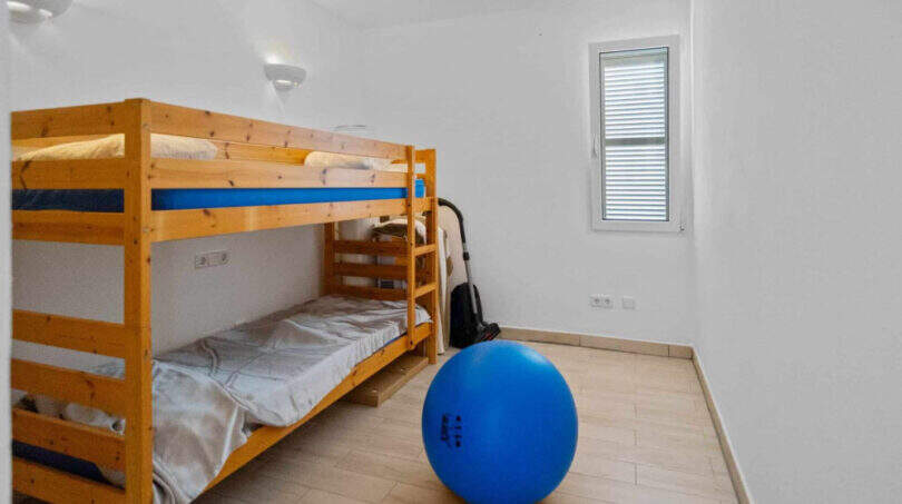 Kinderzimmer mit Holz-Etagenbett, blauem Gymnastikball und Parkettboden im Penthouse Cala d'Or