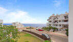 Außenansicht des Penthouse in Cala d'Or mit Meerblick, weißen Apartmentgebäuden und Parkplatz