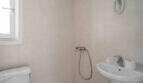 Helles Badezimmer im Penthouse Cala d'Or mit Dusche, Waschbecken, WC und Fenster, cremefarbene Fliesen