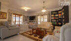 Elegantes Wohnzimmer der Finca in Lloseta mit Kronleuchtern, Sofagruppe, Bücherregal und mediterranem Charme.