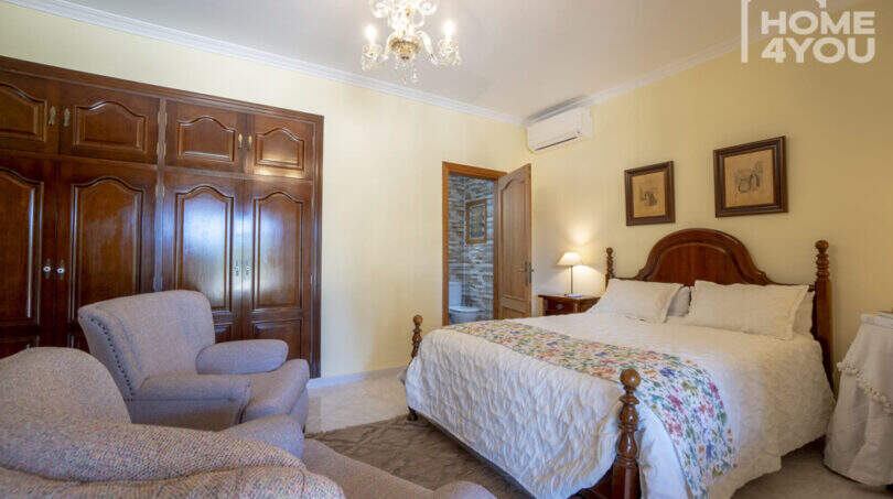 Elegantes Schlafzimmer mit Doppelbett, Holzschrank, Kronleuchter, Klimaanlage & En-suite-Bad der Finca in Lloseta