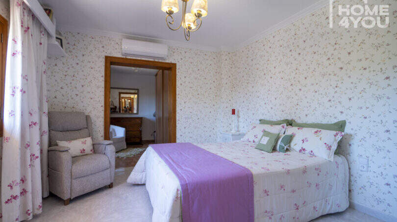Schlafzimmer mit Doppelbett, Blumentapete, Kronleuchter und Klimaanlage in mediterraner Finca, Lloseta