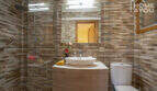 Modernes Badezimmer der Finca in Lloseta mit Dusche, Waschtisch, WC und Naturstein-Wandfliesen.
