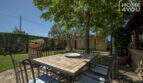 Mediterrane Finca Lloseta: Sonnige Terrasse mit Mosaiksteintisch, Schmiedeeisenstühlen und schattenspendenden Bäumen.