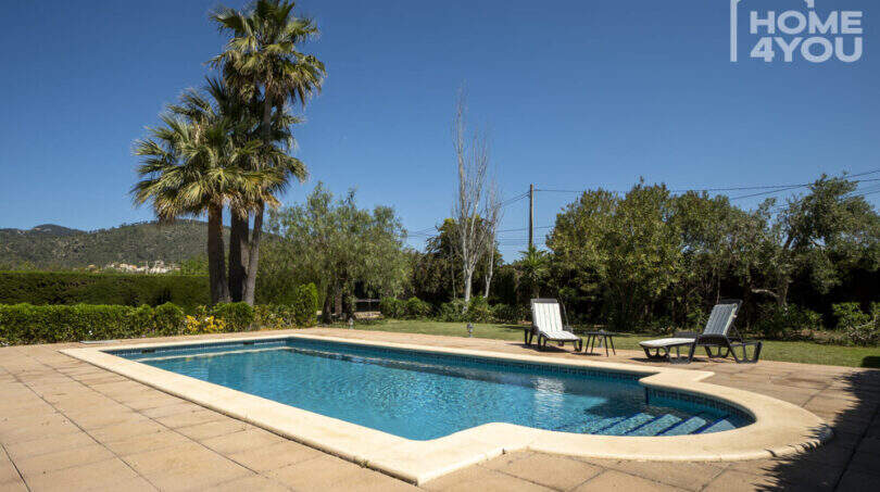 Pool mit Sonnenliegen, Palmen und Bergblick der mediterranen Finca in Lloseta