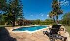 Mediterrane Finca in Lloseta: Großer Pool mit Liegestühlen, Palmen und Bergpanorama im Hintergrund.