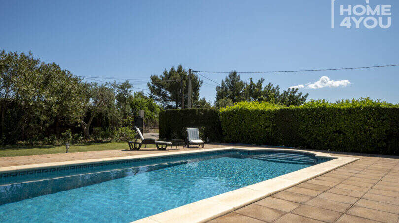Pool mit Sonnenliegen und gepflegtem Grüngürtel der mediterranen Finca in Lloseta, Mallorca