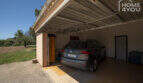 Geräumige Garage der Finca in Lloseta mit VW-SUV, Überdachung und Zugang zum Innenbereich.