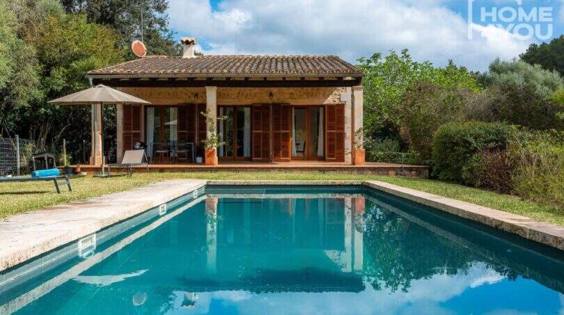 Mediterrane Finca in Campanet: Außenpool mit Blick auf Terrassenhaus, Holzläden & üppigem Grün