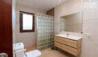 Modernes Badezimmer der Finca mit Glasbausteindusche, Holzwaschtisch und Fenster in Santa Margalida