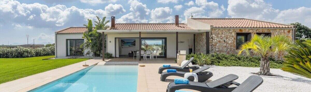 Mediterranean finca in Sa Pobla: panorama pool with sun loungers and natural stone main house