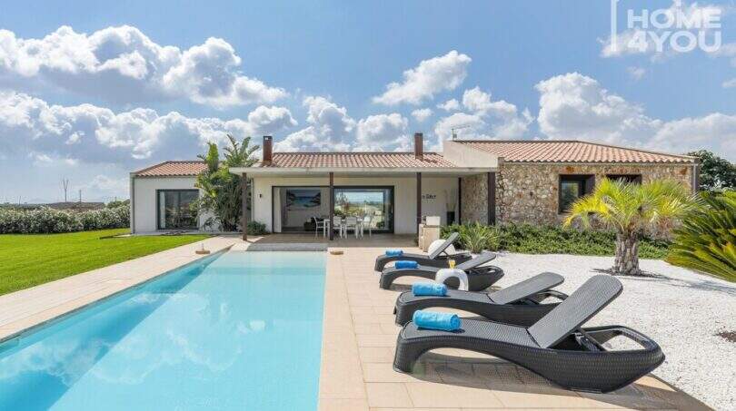 Mediterranean finca in Sa Pobla: panorama pool with sun loungers and natural stone main house