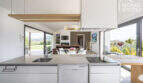 Open kitchen with cooking island, view into living room & Mediterranean garden landscape, finca Sa Pobla