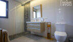 Modern bathroom of the finca in Sa Pobla with walk-in shower, wooden sink and atmospheric lighting.