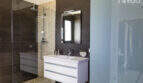 Modern bathroom of the finca in Sa Pobla with walk-in shower, mosaic tiles and floating sink.