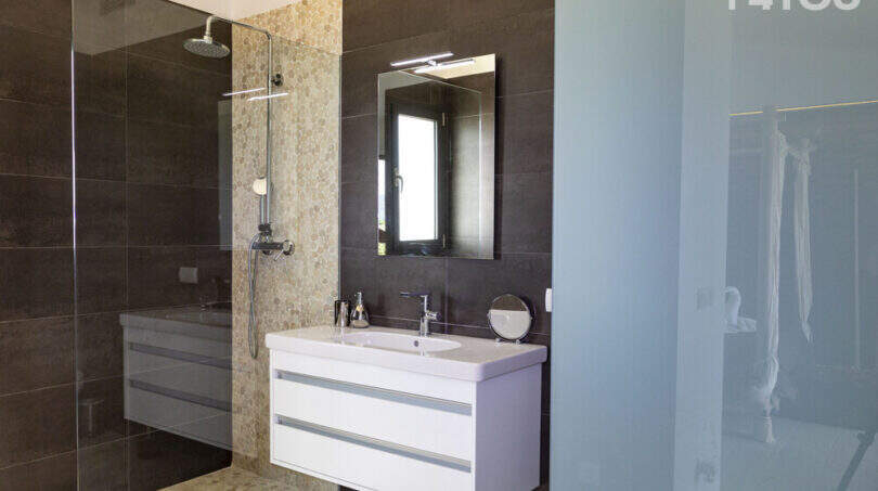 Modern bathroom of the finca in Sa Pobla with walk-in shower, mosaic tiles and floating sink.