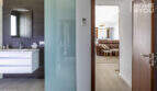 Modern bathroom of the finca in Sa Pobla with sink, mirror and glass partition to living area.