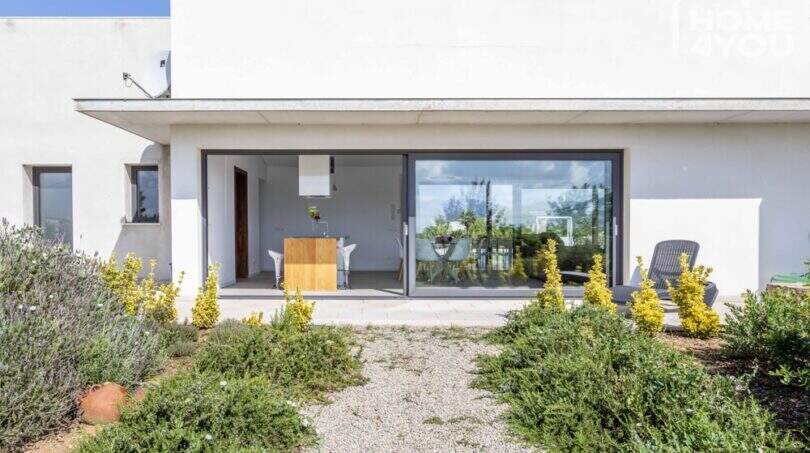 Mediterranean finca in Sa Pobla: modern exterior with panoramic glazing, terrace and Mediterranean garden