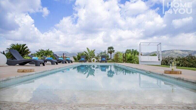 Panorama pool with sun loungers, canopy lounge and mountain view of the Mediterranean finca in Sa Pobla